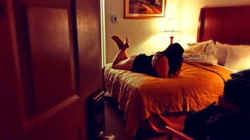 Woman laying on hotel bed waiting for her lover