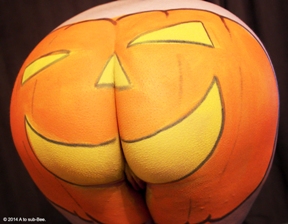 Womans bum painted as a pumpkin with body paint