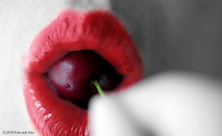 Red lips with red cherry in mouth