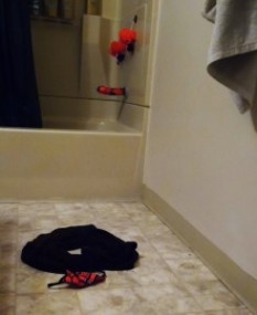 Bathroom scene of discarded clothes and suction dildo