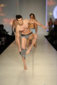 Model taking off pants on catwalk