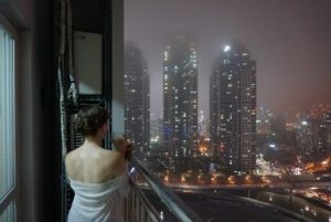 Woman on Balcony overlooking night time city