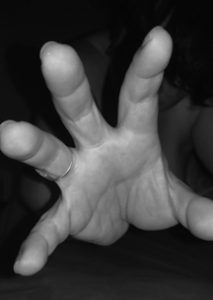hand reaching to the camera out of the darkness