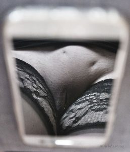 Womans vulva reflected in the screen of a phone