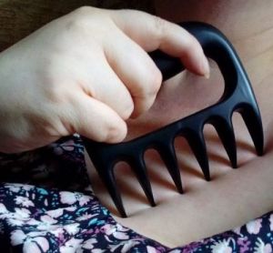 Woman using pulled pork forks to scratch her skin