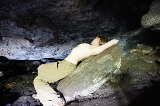 woman laying topless in cave