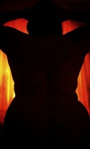 Silhouette of female nude with bright orange light