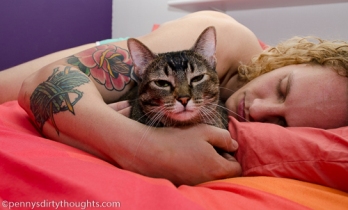 Man in bed with smug tabby cat