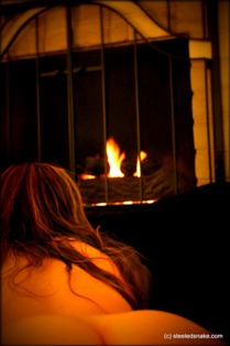 Woman on all fours in front of open fire