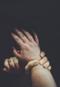 Man holding woman's wrists
