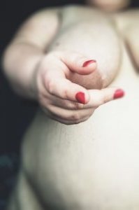 Female nude with hand in focus and body out of focus