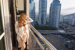 Woman standing on balcont in morning sun with city view sinful sunday sex