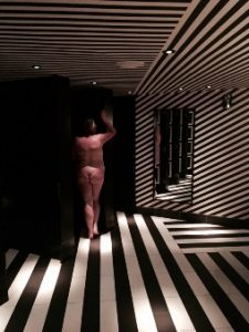 NUde woman in black and white striped bathroom