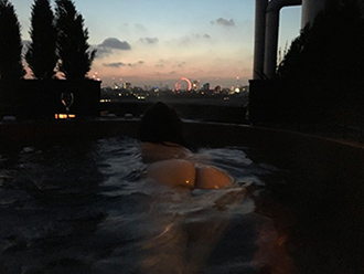 Girl on the net in hot tub over looking London skyline