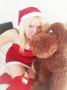 Woman in sexy santa outfit with giant teddy