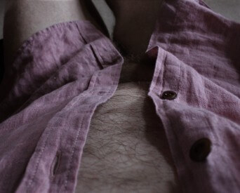 Man in pink linen shirt open to show of his hair chest