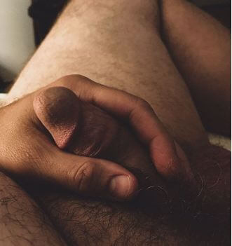 Man tenderly holding his flaccid penis