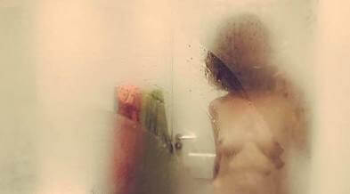 Topless woman in steamed up mirror