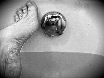 self portrait of woman in the bath relfected in the tap