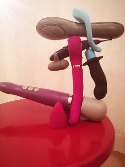 A selection of sex toys balanced on one another in a fun stack
