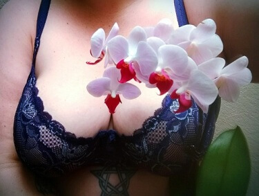 woman in blue bra with orcid flower