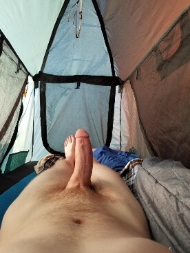 Man laying in tent with hard penis poking up 