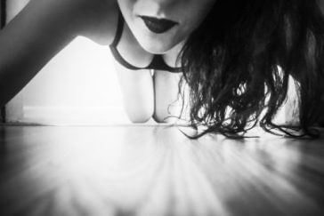 woman in black bra leaning over the camera