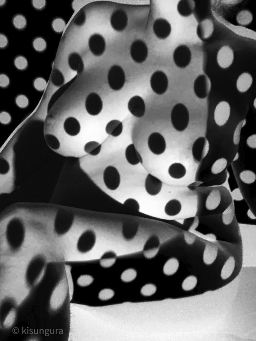 Nude woman covered in shadow polka dots