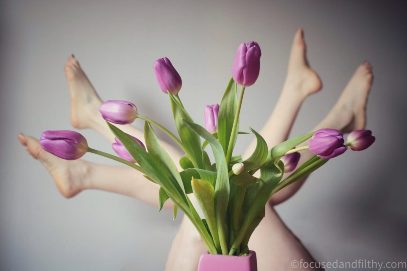 womans legs up in the air behind tulips
