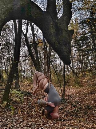 Woman suspended by rope from dragon shaped tree
