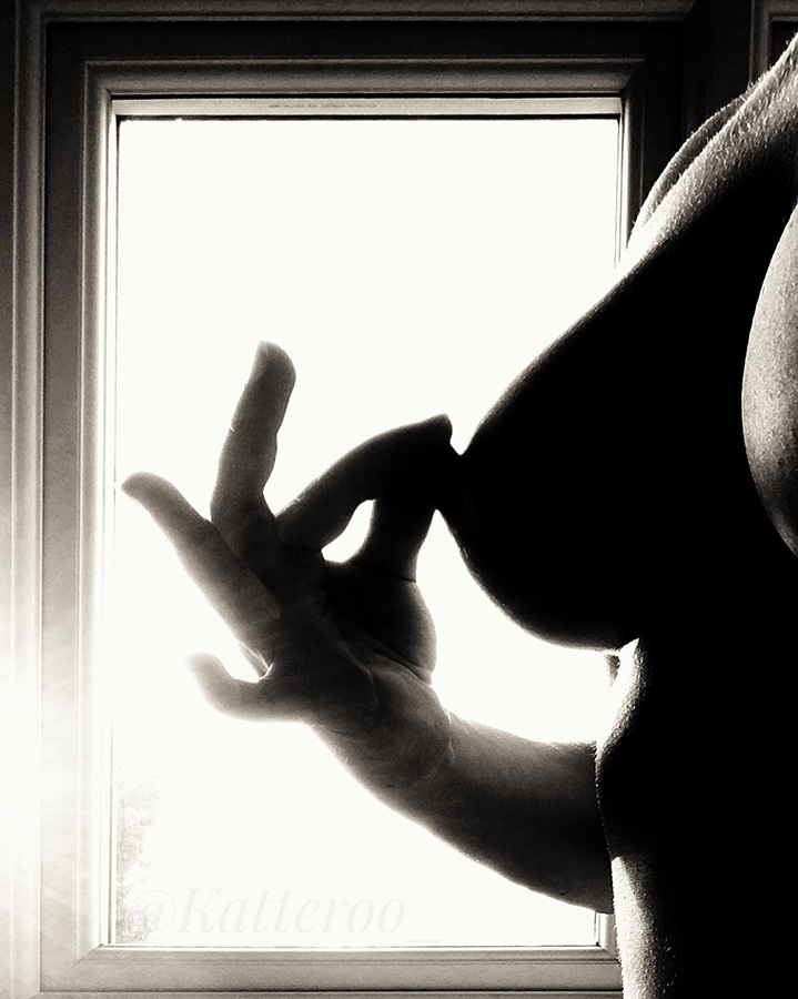 silhouette of woman pinching her nipple