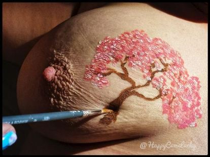 persons breast with blossom tree painted on it