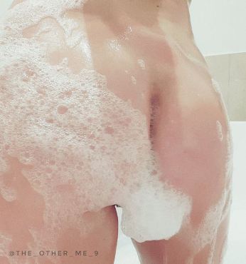 Person naked in shower with bubble that look like a bunny tail on their bum