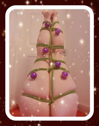 legs tied with green rope and christmas baubles to look like a Christmas tree