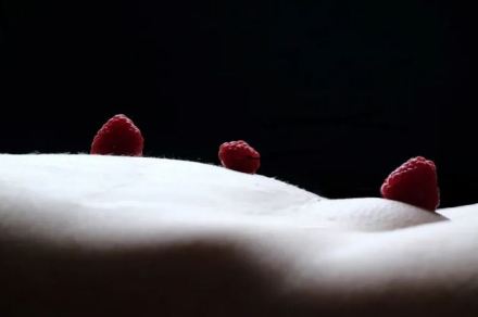 Abstract image of body with raspberries balance on stomach to look like a landscape