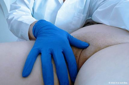 Hand wearing blue medical gloves reaching between thighs to touch labia