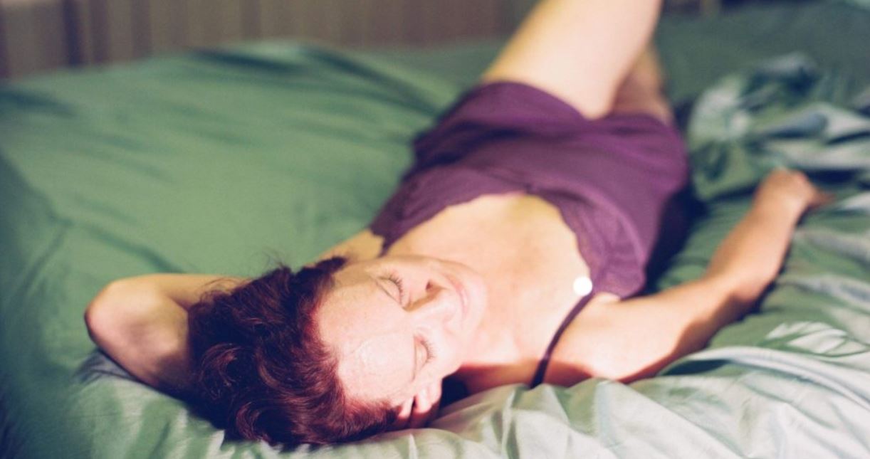 Woman laying in sunshine on bed wearing purple negligee header image for round-up 617