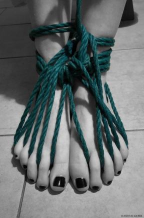 feet tied with dark green rope