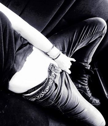 Person laying on sofa pulling their jeans down and pushing their fingers into the opening