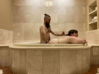Couple in the bath. He is kneeling behind her fucking her from behind, holding her hair in his hand.