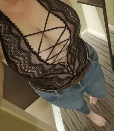 Looking down Puizzi body. She is wearing a lacy body suit and jeans