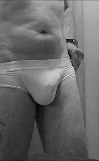 Gif of jer bear taking off his white pants and letting his erect penis pop out