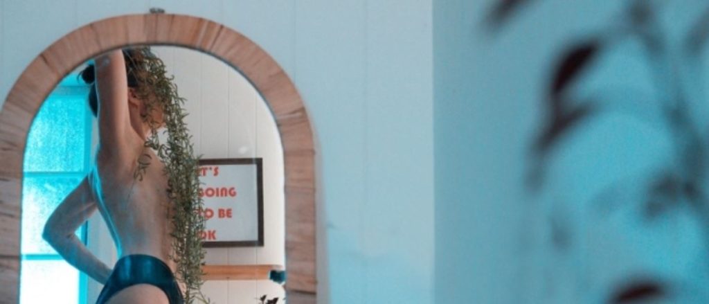 In the left hand lower corner is an arched mirror reflected in that is a nude woman with a house plants in her head. Next to her is a sign that says, it;s going to be OK for weekly round up 690