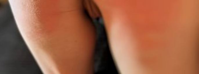 Person crawling away from the camera. They are naked and their bottom is red from spanking and you can see their vulva lips between their thighs