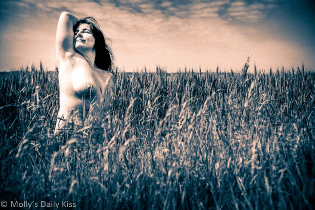 Molly topless in a field of wheat edited with a sepia old movie type colours